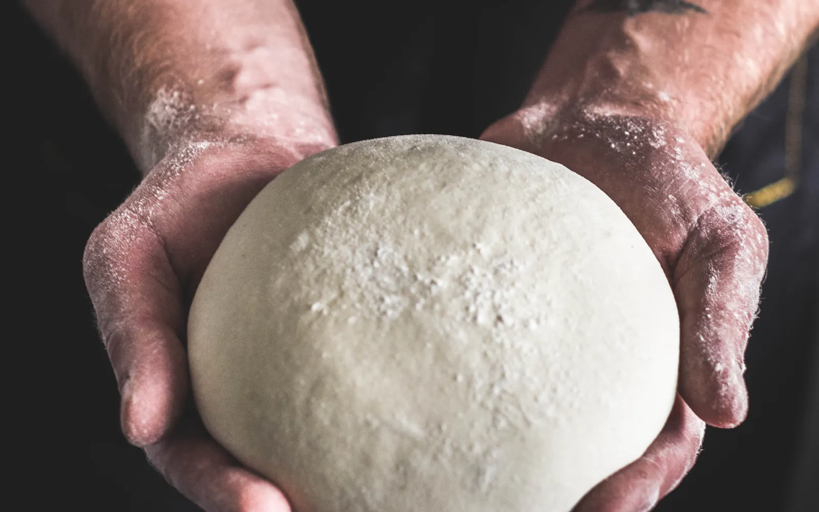 Hands shaping bread dough