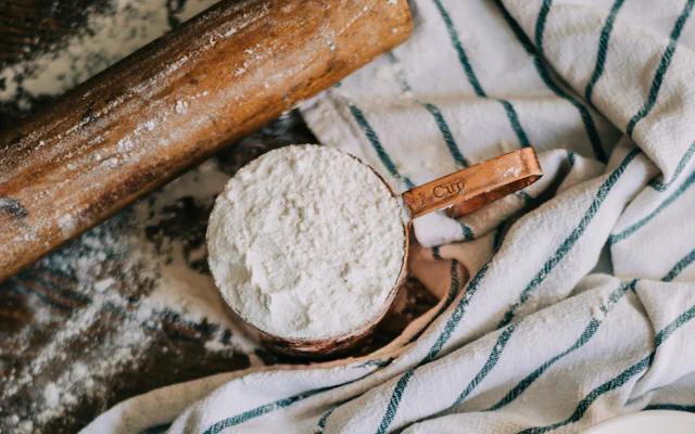 Measuring cup with flour, eggs and butter