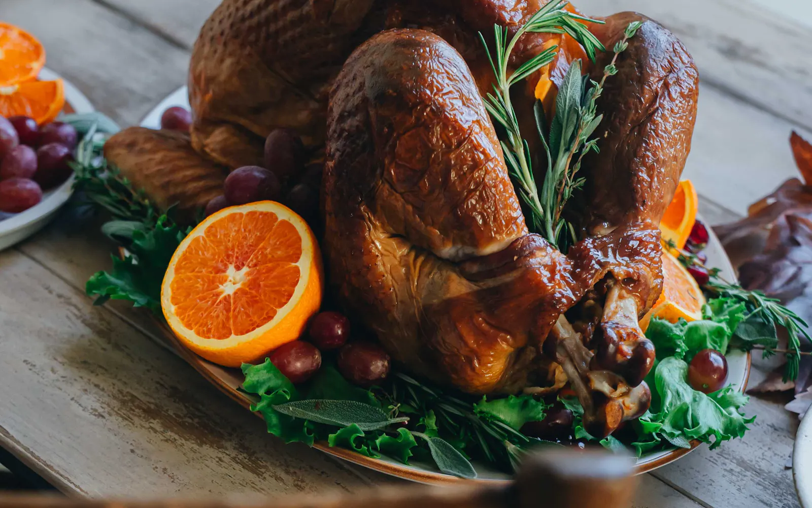 Roast turkey on a platter with oranges and herbs