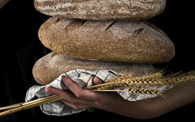 Freshly baked sourdough loaf held in hands
